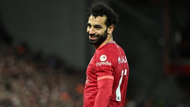 Penyerang sayap Liverpool, Mohamed Salah tersenyum pada laga Liga Inggris kontra Manchester United di Anfield, Rabu (20/4/2022) pagi WIB. [Oli Scarff / AFP]
